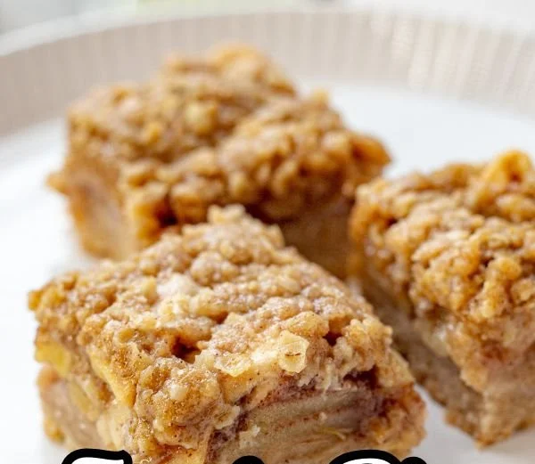 Delicious apple pie bars topped with crunchy streusel on a wooden table