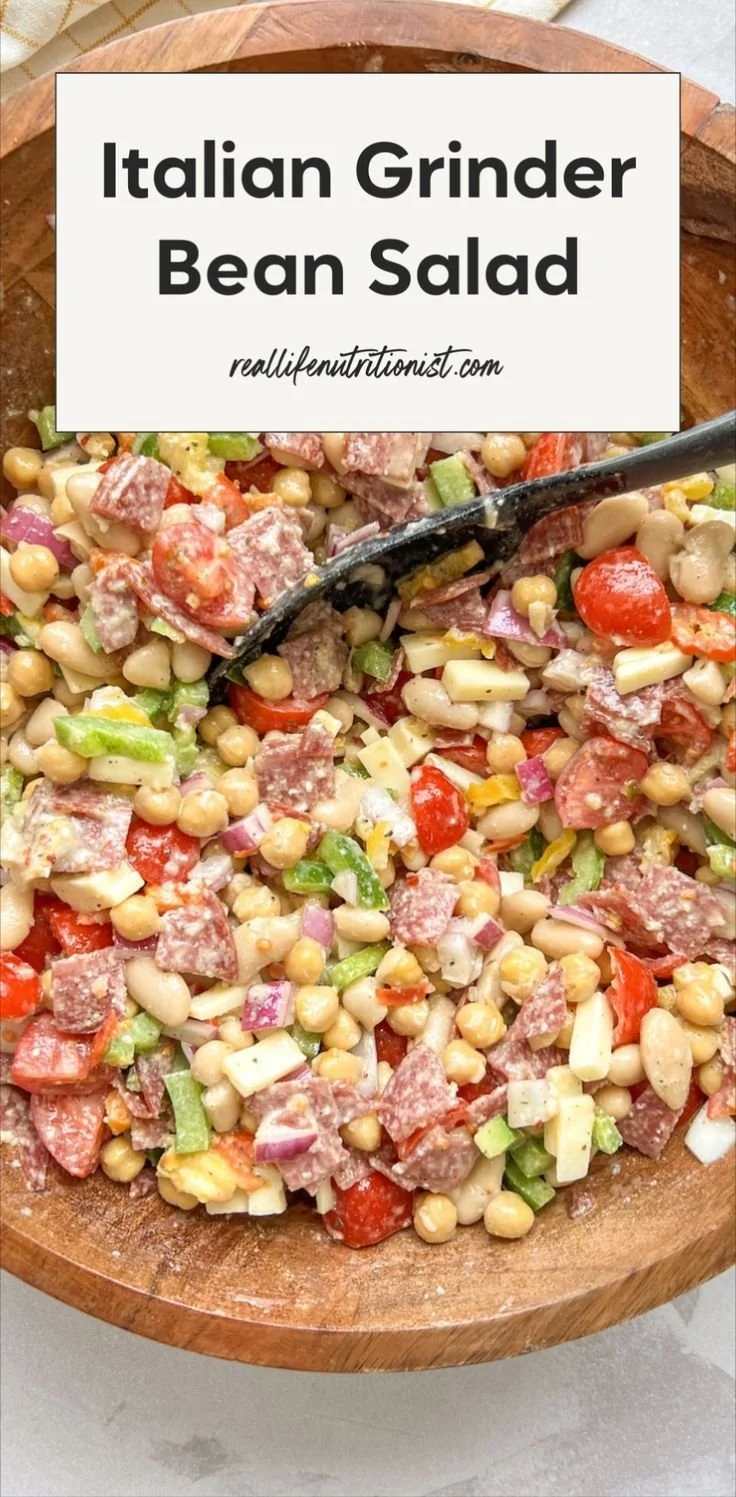 Colorful bean salad with chickpeas, fresh vegetables, and dressing.