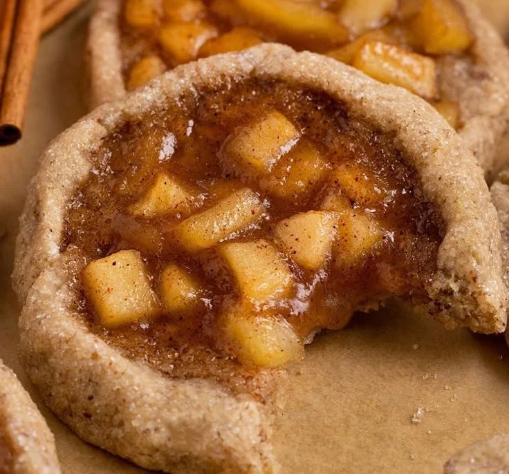 Chewy vegan apple pie cookies fresh out of the oven, topped with cinnamon.