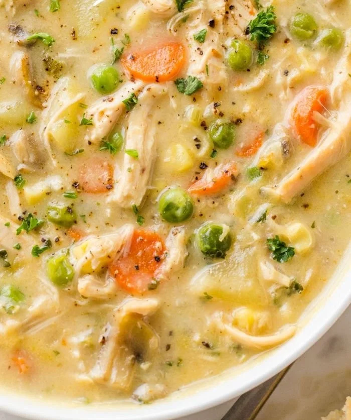 Bowl of Chicken Pot Pie Soup with vegetables and flaky pastry topping