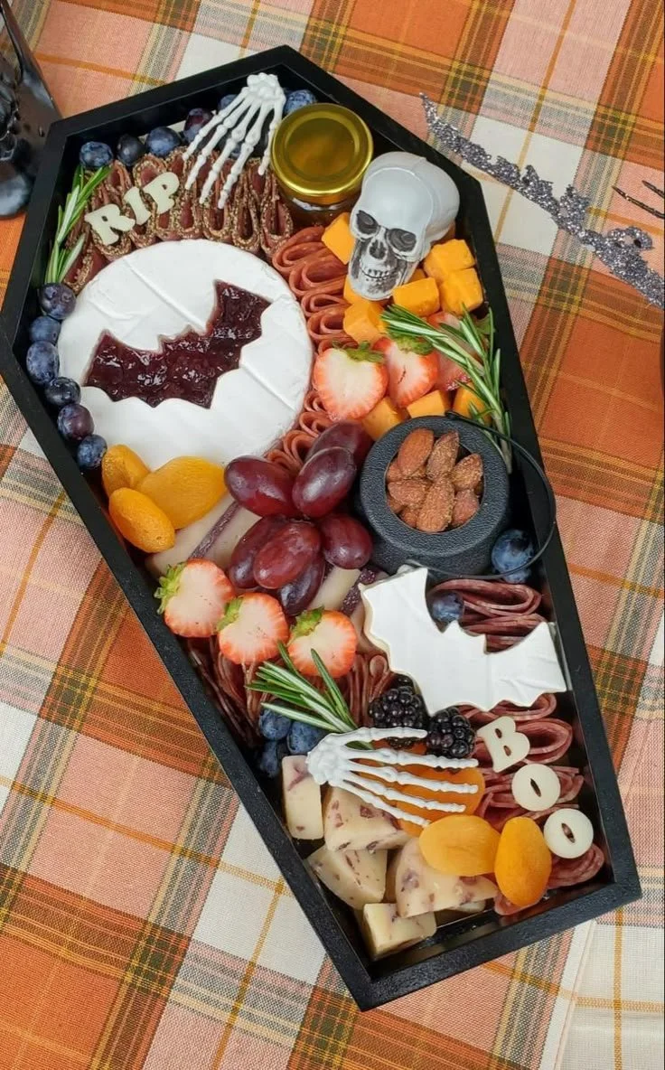Coffin charcuterie board filled with meats, cheeses, and snacks for Halloween events