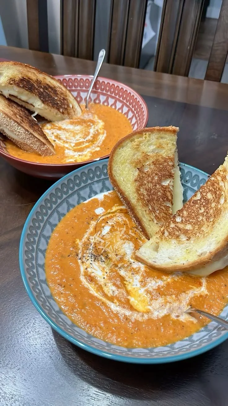 Bowl of homemade creamy tomato soup served with a grilled cheese sandwich