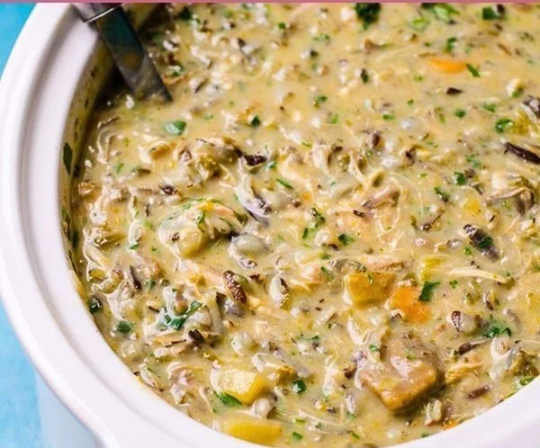 Creamy and healthy chicken wild rice soup in a bowl with fresh herbs