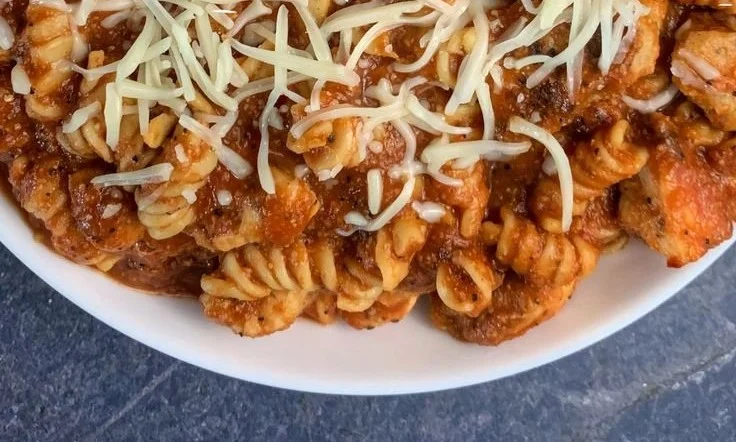 Healthy Garlic Parmesan Chicken Pasta dish garnished with fresh herbs