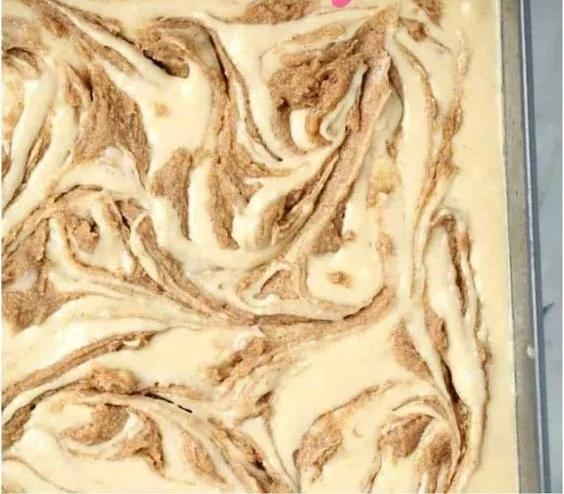 Homemade cinnamon roll cake with cinnamon swirls and icing on top.