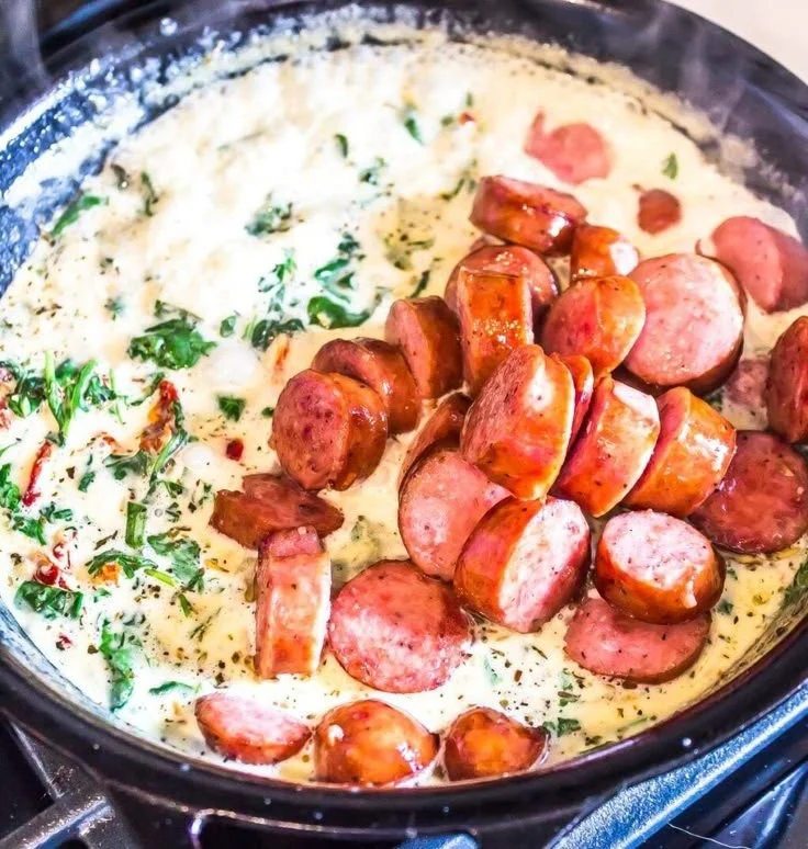 Keto creamy Tuscan zucchini noodles topped with sausage in a bowl