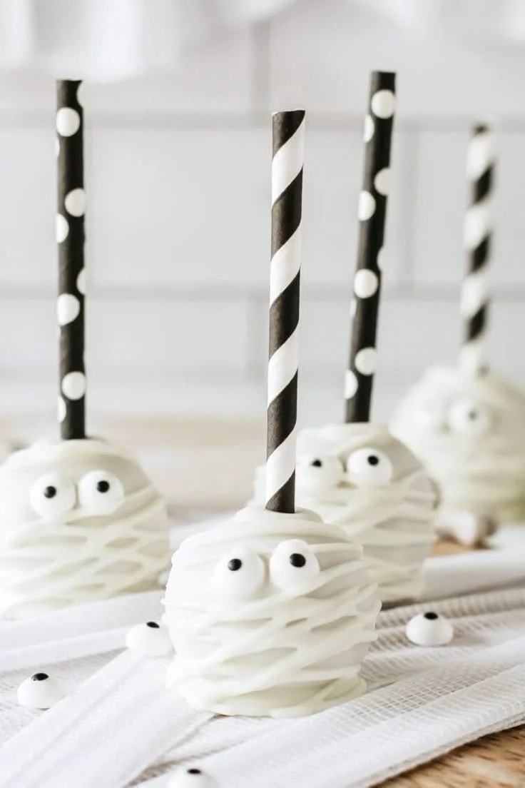 Halloween Mummy Cake Pops decorated with white chocolate and candy eyes.