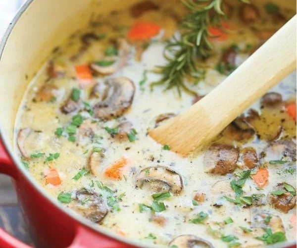 Delicious Mushroom and Chicken Soup in a bowl, garnished with fresh herbs.