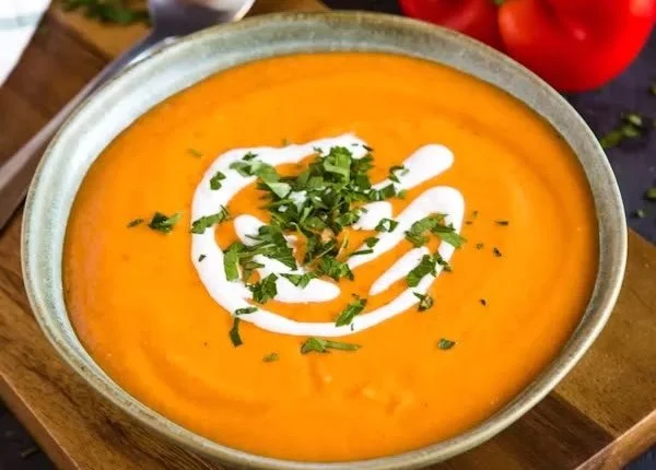 Delicious roasted red pepper cauliflower soup in a bowl with fresh herbs