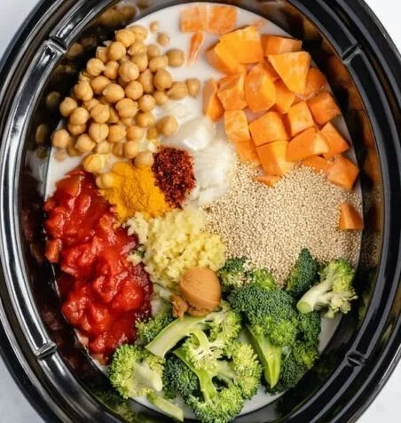 Bowl of slow cooker coconut curry with vibrant vegetables and fresh herbs.