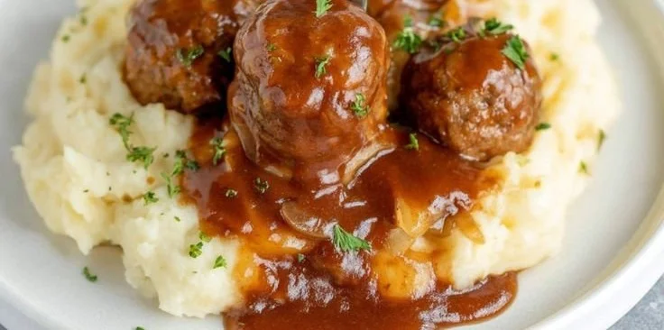 Slow Cooker Salisbury Steak Meatballs served with gravy and mashed potatoes.