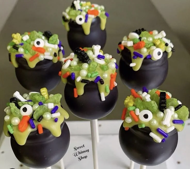 Delicious Halloween cake pops in festive designs including ghosts and pumpkins.