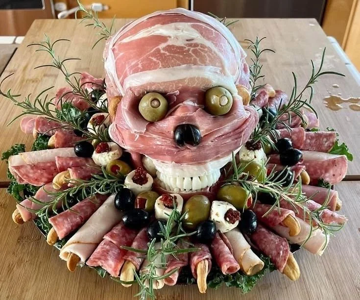 Halloween party tray featuring spooky meat and cheese combination with olives.
