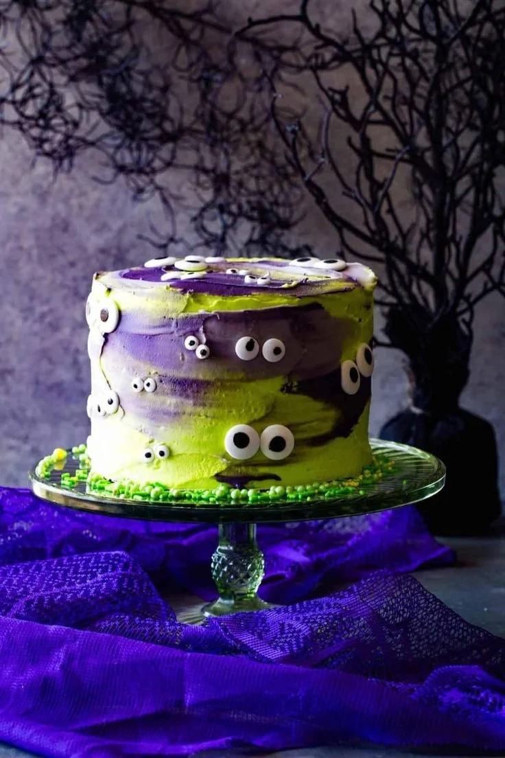 Monster Halloween cake with neon green frosting and giant eyes for Halloween celebrations.