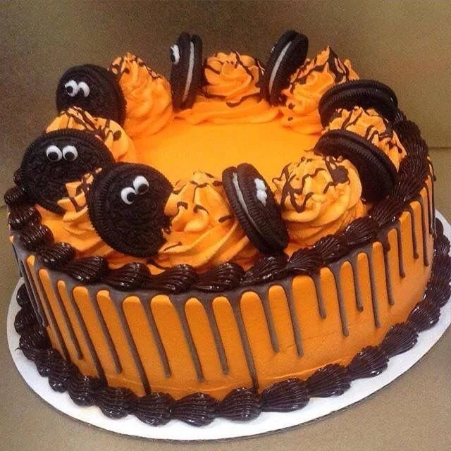 Spooky Halloween cake with themed decorations and cookies for a festive party.